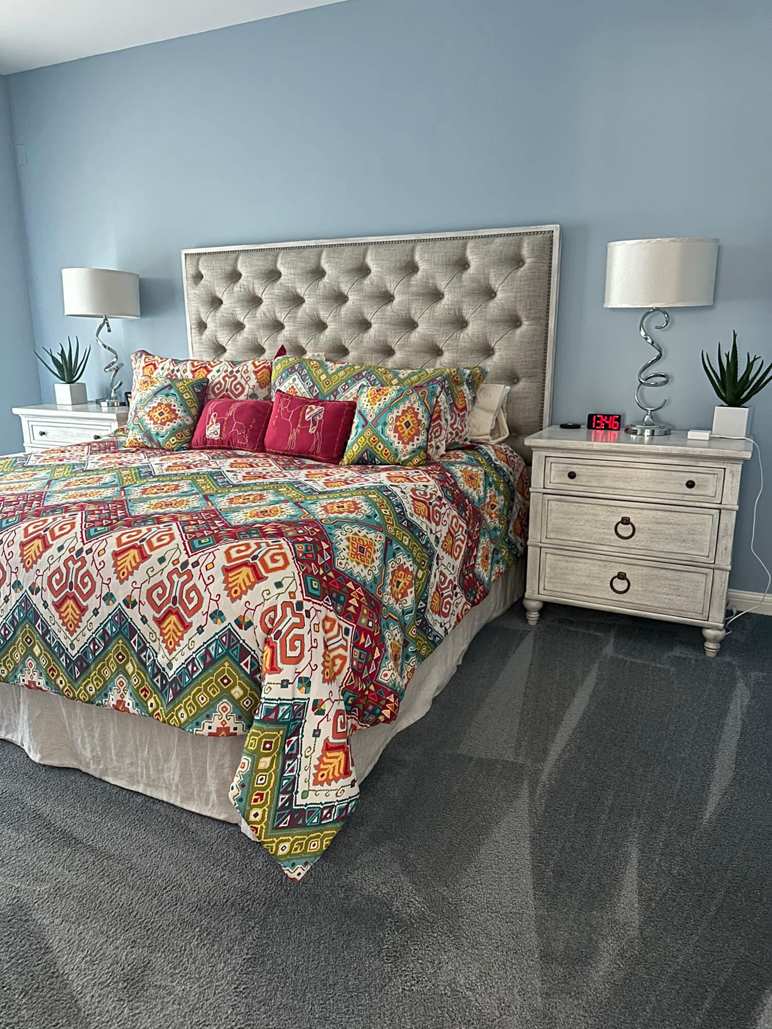 Freshly cleaned bedroom with neatly made bed and vacuumed carpet