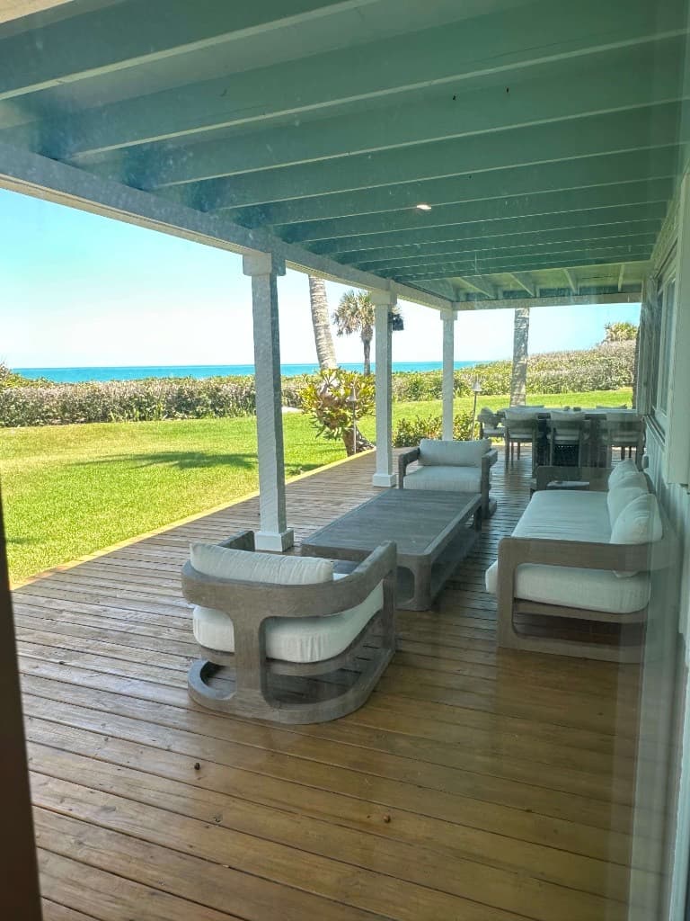 Luxury beachfront porch with ocean views and well-maintained outdoor furnishings