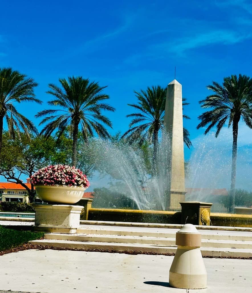 Pristine community plaza with fountain, landscaping, and palm trees