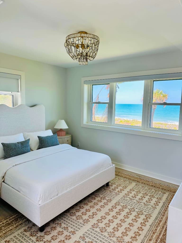 Bright coastal bedroom with crystal-clear windows and ocean views