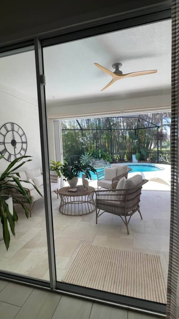 Spotless sliding glass doors opening to a screened patio and pool